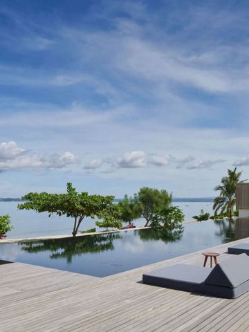 Infinity-Pool mit Meerblick und Sonnenliegen unter blauem Himmel