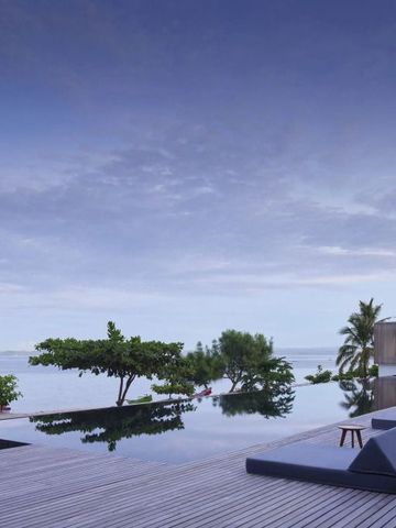 Infinity Pool mit Blick auf das Meer und tropische Vegetation