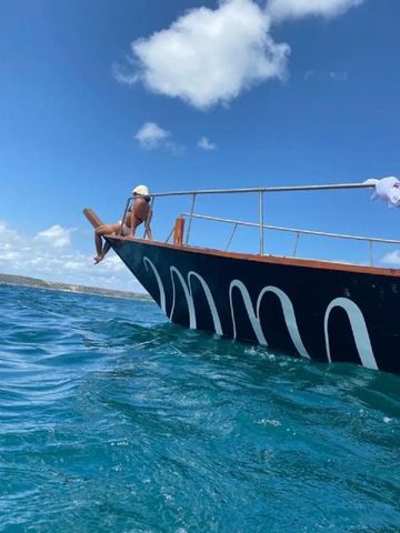 Ein Boot segelt auf offenem Meer unter klarem Himmel