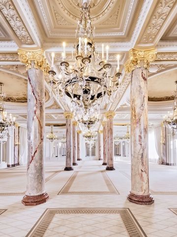 Eleganter Ballsaal des Carlton Cannes mit prachtvollen Kronleuchtern und Marmorsäulen.