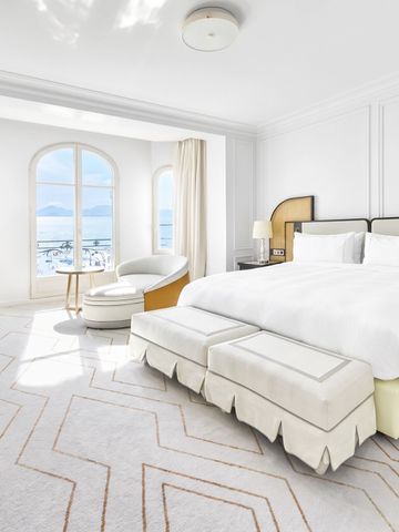 Helles Hotelzimmer im Carlton Cannes mit Meerblick und eleganter Einrichtung.