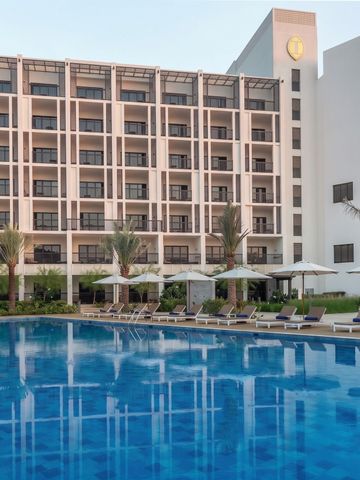 Moderner Hotelbau mit großem Außenpool und stilvollen Sonnenschirmen.