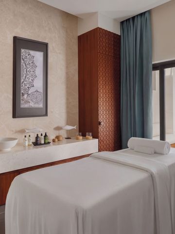 Luxuriöser Spa-Behandlungsraum mit Massageliege und Vorhängen