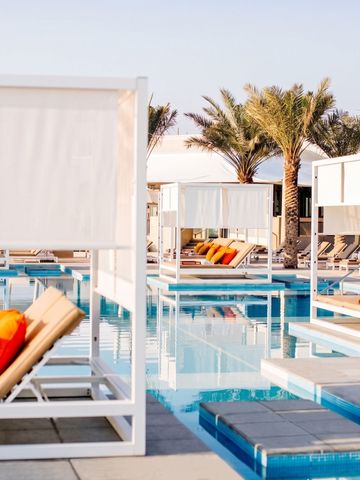 Sonnenliegen am Pool mit Palmen im Hintergrund im InterContinental Fujairah Resort