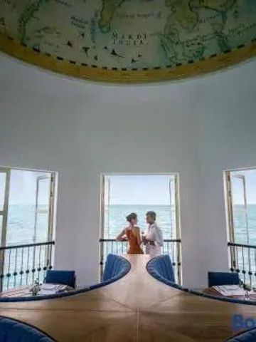 Rundbau mit Blick auf das Meer und kunstvoll bemalter Decke mit Weltkarte.