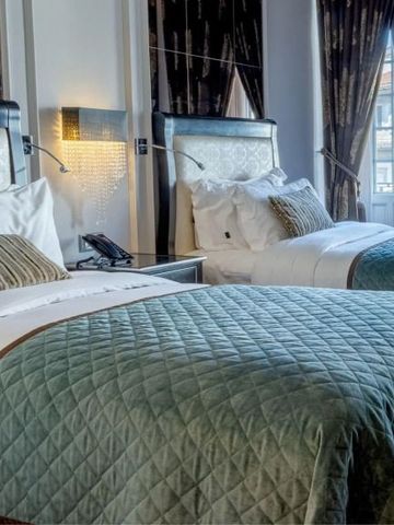 Zwei große Betten in elegantem Hotelzimmer mit luxuriösen Vorhängen im InterContinental Porto
