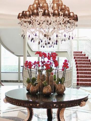 Prächtiger Kronleuchter in eleganter Hotellobby mit Orchideen