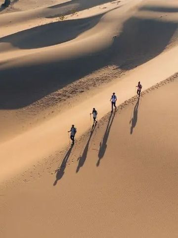Wüstenlandschaft mit wandernden Menschen im Sanddünen