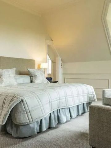 Gemütliches Schlafzimmer mit großem Fenster und bequemem Sessel