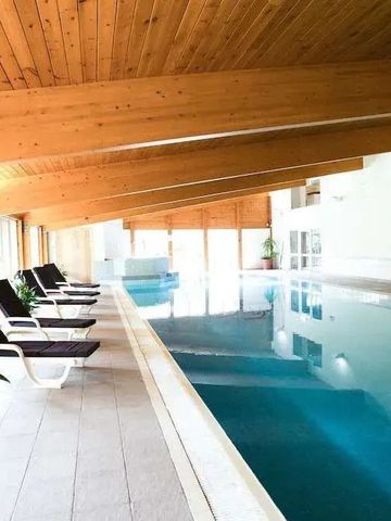 Innenpool mit Holzdecke und Liegestühlen