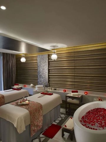 Luxuriöses Spa-Zimmer mit Massageliegen und Whirlpool. Entspannende Atmosphäre.