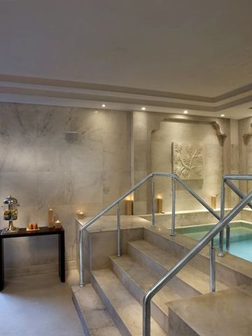 Exklusiver Spa-Bereich mit kleinem Pool und hellen Natursteinelementen.