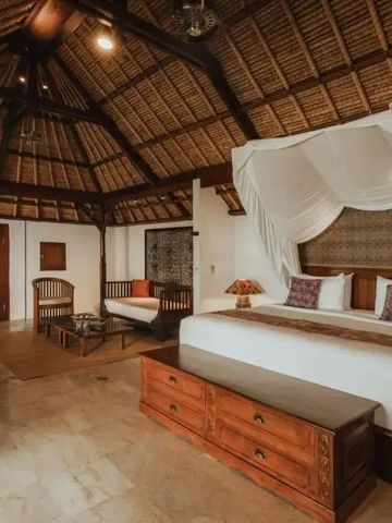Großes Zimmer mit traditioneller Holzdecke und Himmelbett.
