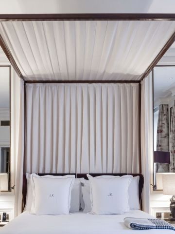Elegantes Schlafzimmer mit Himmelbett und hochwertigen Textilien