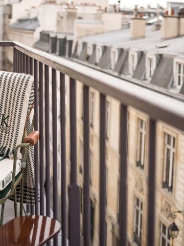 Balkon mit Ausblick auf Pariser Gebäude und eleganter Bestuhlung