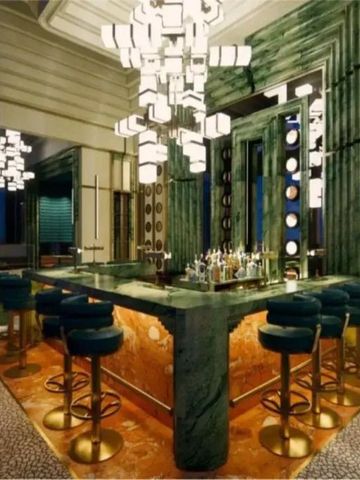 Art-déco-inspirierte Hotelbar mit luxuriösen grünen und goldenen Akzenten
