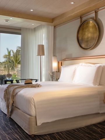 Luxuriöses Hotelzimmer mit großem Bett, Balkon und Meerblick.