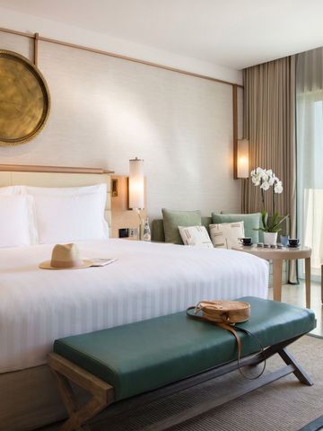 Stilvolles Zimmer mit Doppelbett, Balkon und eleganten Möbeln.
