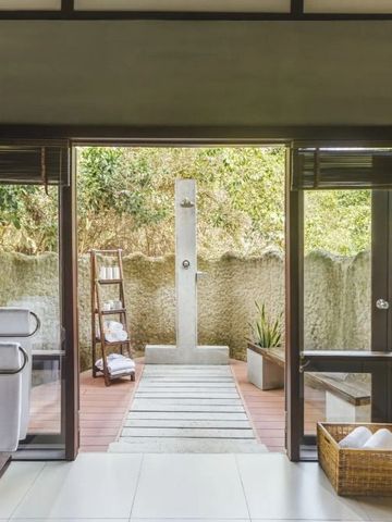 Offener Duschbereich mit Blick in den grünen Garten
