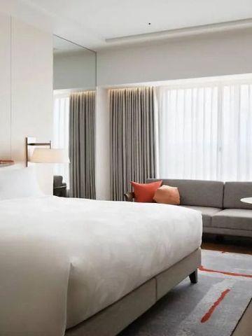Zimmeransicht mit großem Bett, Sofa und zeitgenössischer Dekoration