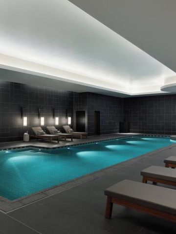 Großer Innenpool mit modernen Liegen und stilvoller Beleuchtung in einem luxuriösen Ambiente.