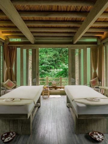 Spa-Behandlungsraum mit zwei Massagetischen in einer natürlichen Umgebung