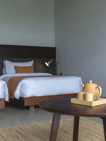 Doppelzimmer mit minimalistischer Einrichtung und Teeservice auf Holztisch