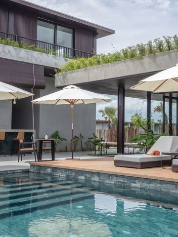 Moderner Poolbereich mit Liegen und Sonnenschirmen vor einer Villa
