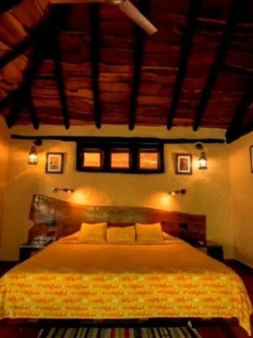 Schlafzimmer mit Holzbalkendecke und warmen Farben