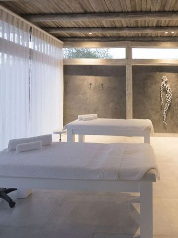 Modernes Spa-Zimmer mit zwei weißen Massageliegen und elegantem Design