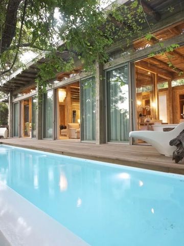 Privater Pool vor einer Villa mit Glasfront und moderner Einrichtung