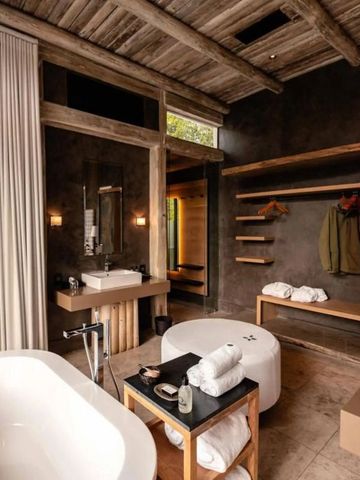 Luxuriöses Badezimmer mit freistehender Badewanne und rustikalen Holzelementen