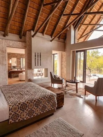 Großzügiges Schlafzimmer mit Blick auf die Natur und elegante Ausstattung