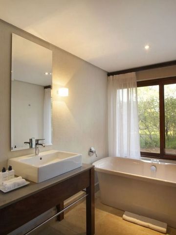 Modernes Badezimmer mit Badewanne und Ausblick ins Grüne