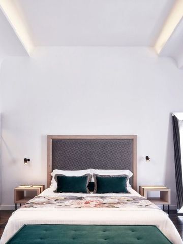 Modernes Hotelzimmer mit stilvollem Kopfteil und grünen Kissen