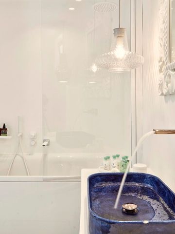 Elegantes Badezimmer mit blauem Waschbecken und luxuriöser Armatur