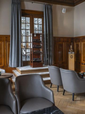 Gemütliche Lounge mit holzvertäfelten Wänden und eleganten Sitzmöbeln