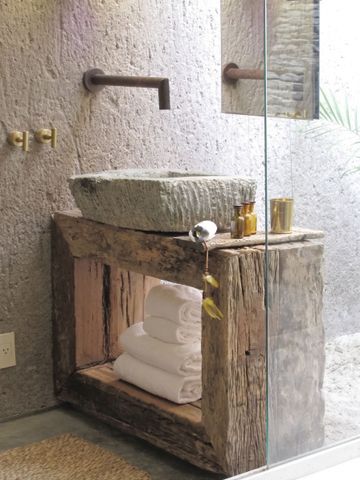 Luxuriöses Badezimmer mit Waschbecken aus Stein und rustikalen Holzelementen