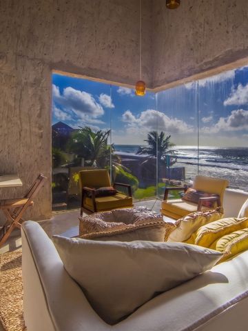 Wohnbereich einer Suite mit Panoramablick auf den Ozean und stilvoller Einrichtung
