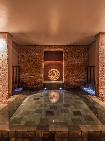 Luxuriöser Innen-Spa mit warmem Licht und Steinwänden
