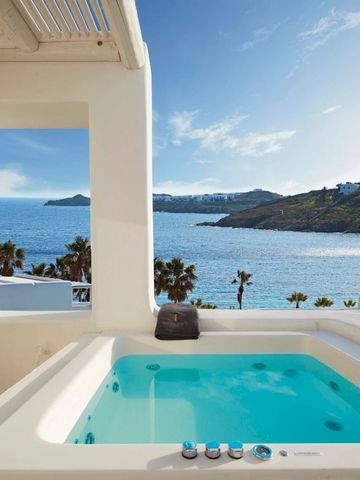Privater Whirlpool mit Meerblick auf einer Terrasse unter blauem Himmel