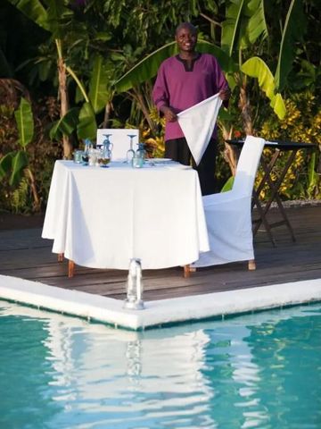 Gedeckter Tisch am Pool in tropischer Umgebung