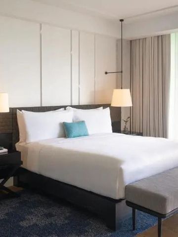 Modernes Hotelzimmer mit großen Fenstern und Gartenblick.