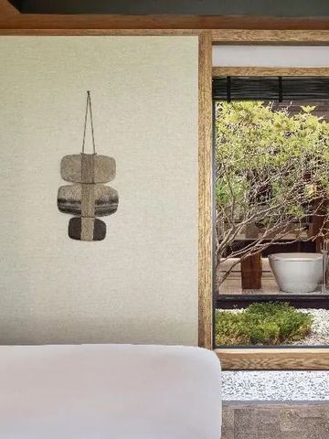 Zimmer mit Blick auf einen begrünten Innenhof und moderner Wanddekoration