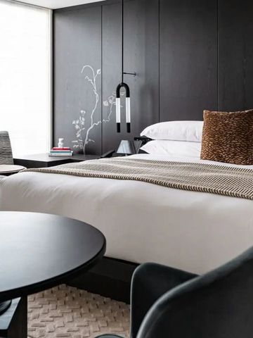 Stylisches Zimmer mit großem Bett, modernem Dekor und Sitzbereich.