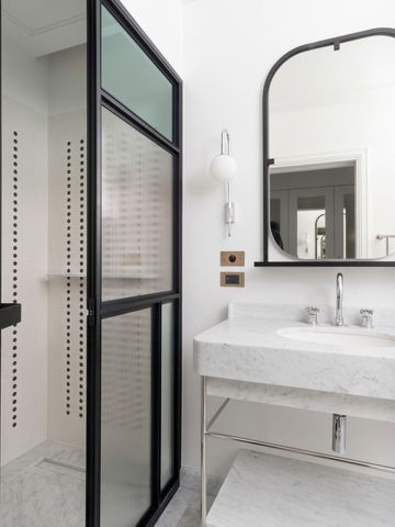 Elegantes Badezimmer mit Waschbecken und großem Spiegel.