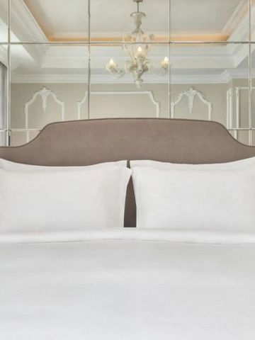 Detailaufnahme eines stilvollen Hotelbettkopfteils mit Spiegelwand