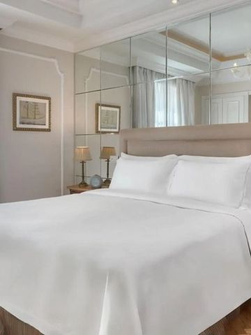 Modern eingerichtetes Hotelzimmer mit großem Bett und Spiegelwand