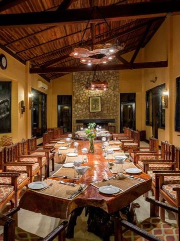 Eleganter Speisesaal mit langen Holztischen und zahlreichen Sitzplätzen