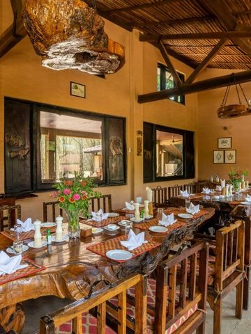 Großer Esstisch aus Holz in rustikalem Speisesaal mit gedecktem Tisch